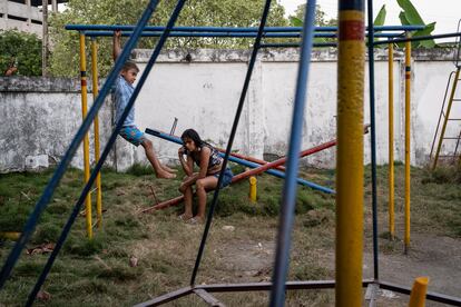 Mara Qui?ones hace una llamada en busca de noticias sobre sus hermanas, mientras su sobrino juega en el parque del refugio.