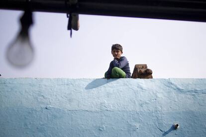 Un niño descansa en un tejado tras salir de la escuela en Agra, India