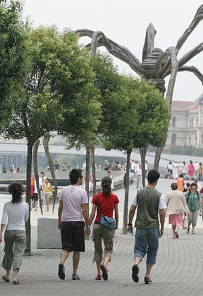 Turistas pasean por Abandoibarra, junto al Museo Guggenheim.