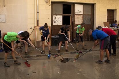 Un grupo de jóvenes limpian las calles de Tafalla tras la lluvias. 