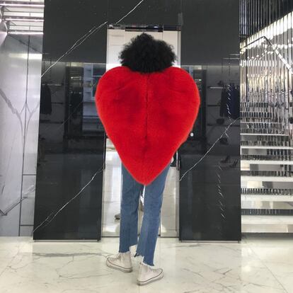 Aquí, la editora de moda Julia Sarr-Jamois posando de espaldas con la creación de Saint Laurent. Lejos de evitar ponerse un diseño que ya han lucido otras celebrities, cada vez son más las que se suman a la fiebre por el abrigo-emoji.