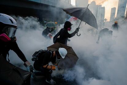Manifestantes antigubernamentales se protegen con paraguas de los gases lacrimógenos durante una manifestación cerca del Complejo del Gobierno Central en Hong Kong (China).