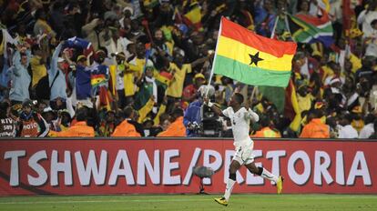 El jugador de Ghana John Pantsil pasea por el césped una bandera de Ghana para festejar el triunfo contra Serbia en el Mundial de Fútbol de Sudáfrica de 2010.