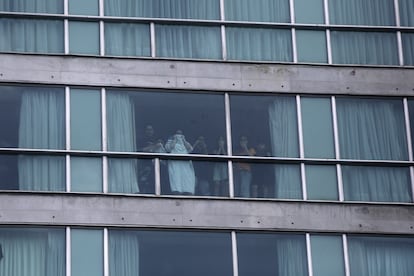 Personas miran desde una ventana del hotel Decápolis, en Ciudad de Panamá, tras ser deportados de Estados Unidos el 18 de febrero.