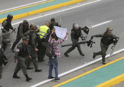 Miembros de la Guardia Nacional de Venezuela se llevan la cámara de una televisión local, durante una protesta en Caracas. 