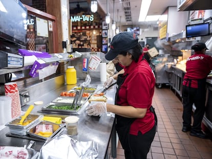 An employee prepares a hot dog at a restaurant in Chicago, Illinois, US, Sept. 27, 2022.