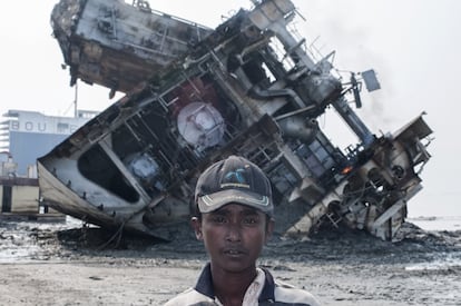 Um adolescente que trabalha no desmantelamento de barcos. Ao fundo, um navio que está sendo reduzido a sucata em Chittagong (Bangladesh). O que os trabalhadores mais temem são os bolsões de gás que se formam nos tanques de combustível e que, muitas vezes, explodem, deixando muitos mortos.