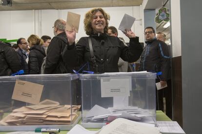 Una mujer con las papeletas para Congreso y Senado antes de votar en un colegio electoral de Barcelona.