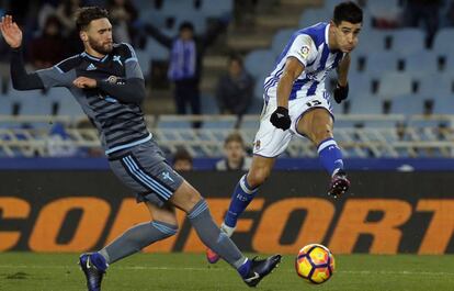 Yuri Berchiche, lateral de la Real, chuta a gol ante la oposici&oacute;n del zaguero Sergi G&oacute;mez.