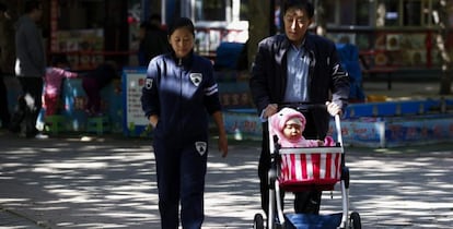 Un abuelo pasea con su nieto y su hija por un parque de Pek&iacute;n (China).