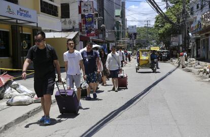 El sector turístico advirtió que el cierre de la isla pone en peligro 17.000 empleos. La isla recibió en 2017 casi dos millones de turistas que generaron 1.000 millones de dólares para la economía filipina. En la imagen, turistas caminan por la isla de Boracay, el 25 de abri de 2018.