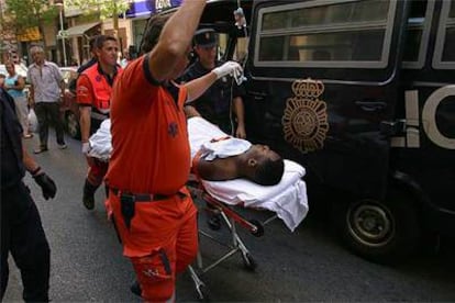 Personal sanitario traslada a uno de los heridos ayer durante una operación policial en Málaga.