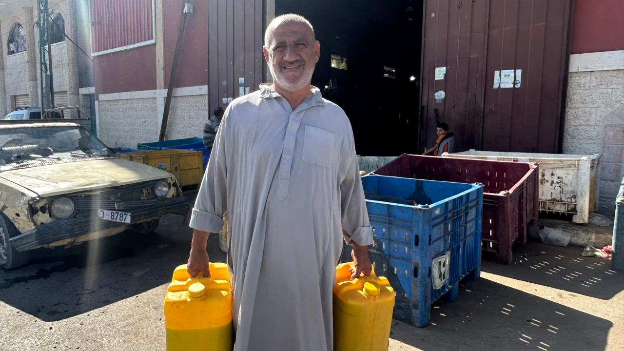 Bassam Abdullah, con dos garrafas de aceite procedente de sus olivos, a principios de octubre.