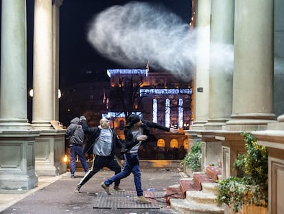 Manifestantes arrojan piedras contra el ayuntamiento de Belgrado, durante la protesta por el supuesto fraude electoral de este domingo en la capital serbia.