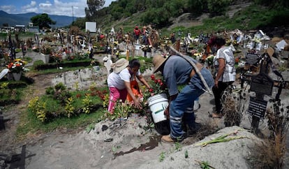 Familiares de un fallecido por coronavirus en un cementerio, en México.