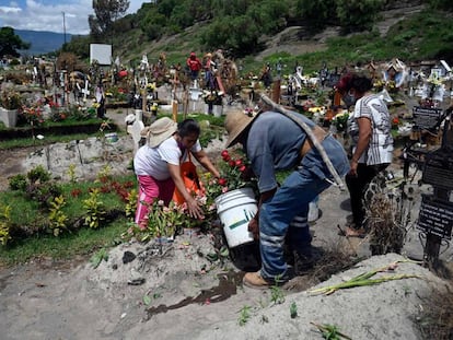 Familiares de un fallecido por coronavirus en un cementerio, en México.