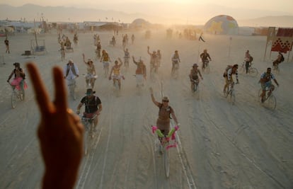 A lo largo de la semana que dura Burning Man (Hombre en llamas en inglés), un evento anual en el desierto de Nevada (EE UU), las decenas de miles de participantes lo llamarán de otras maneras: experimento sociológico, espectáculo sin espectadores, laboratorio de contracultura, parque de atracciones gigante para adultos... En la imagen, un grupo de asistentes al festival utilizan sus bicicletas por la zona conocida como "la playa".