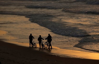 Niños palestinos montan en bicicleta en la playa de la ciudad de Gaza.

