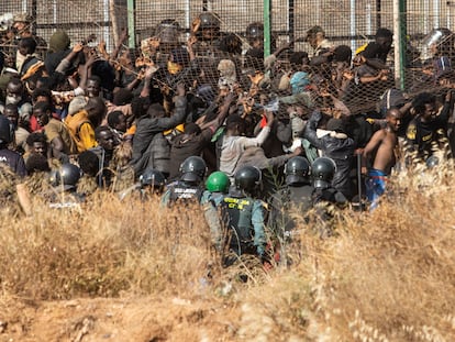 Migrantes intentan cruzar la valla de Melilla el viernes desde Marruecos, salto en el que fallecieron al menos 18 personas.