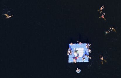 Un passeig gràfic per gaudir a vista d'ocell de mantells de colors que són camps de flors, formigues que són persones, geometries terrenals que semblen obres d'art... Imatges seleccionades d'entre els milers de fotografies que les agències d'informació gràfica han enviat al diari en els últims mesos. A la imatge, banyistes i gent prenent el sol en una plataforma flotant al llac Silbersee a Haltern, Alemanya.