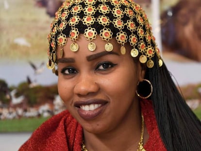 Mulher com penteado tradicional do Sudão posa no estande promocional de seu país na Feira Internacional de Turismo de Madri (Fitur).