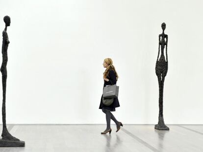 Una visitante pasea entre <i>Grande Femme IV </i>(izquierda) y <i>Grande Femme III</i> en la exposición dedicada a Alberto Giacometti en la Fundación Beyeler, en Riehen (Suiza) en 2009.