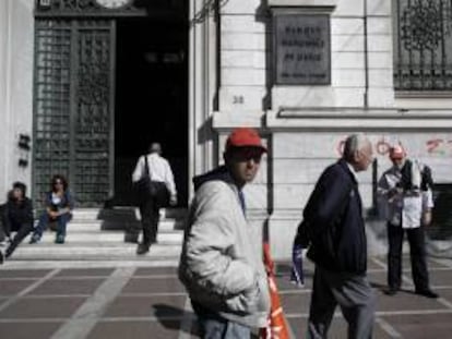 Varias personas pasean delante de la sede del Banco de Grecia. EFE/Archivo