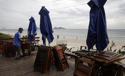 Trabalhador recolhe as cadeiras de um bar na orla do Rio de Janeiro, proibido de abrir após as 17h, desde a sexta-feira, 5 de março.