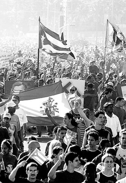 Manifestantes cubanos contra EE UU portan una bandera española en La Habana en mayo de 2004.