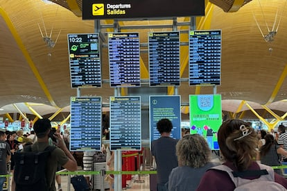 Un grupo de viajeros esta mañana ante las pantallas de información de la terminal 4 del aeropuerto de Madrid-Barajas.