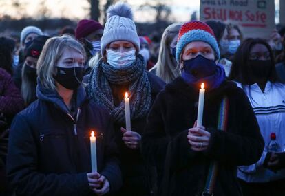 Tres jóvenes con velas en el memorial por Sarah Everard en Clapham Common.