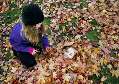 Dos niñas juegan con las hojas caídas de los árboles en un parque de Estocolmo, 13 de octubre de 2013.