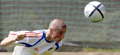 Torres, con su nuevo corte de pelo, cabecea un balón en el entrenamiento de ayer.