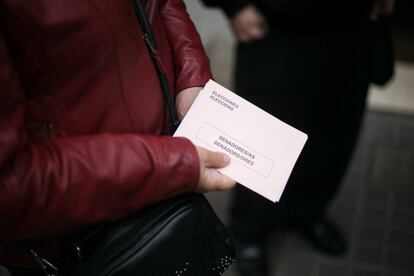 Una dona sost un sobre amb el vot pel Senat preparat a la porta del collegi electoral Santa Marta, a l'Hospitalet de Llobregat.