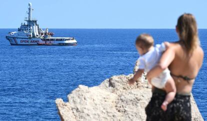 Una mujer observa el Open Arms desde la costa de la isla de Lampedusa.