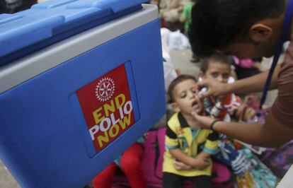 Un trabajador sanitario administra la vacuna de la polio a un niño, durante la campaña realizada en Karachi (Pakistán).