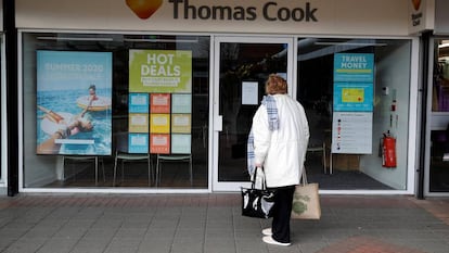 Una mujer delante de una oficina de Thomas Cook en el Reino Unido.