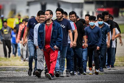 Guatemalan migrants deported from the United States walk on the airport runway upon their arrival at the Air Force Base in Guatemala City on June 21, 2023.