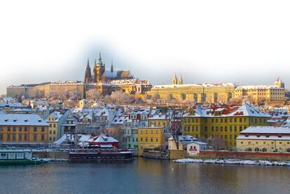 Vista de la ciudad de Praga con nieve desde el río Danubio.