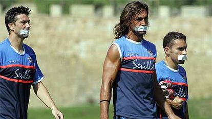 Los capitanes del Sevilla, Martí, Javi Navarro y David, posan con un esparadrapo en la boca.