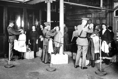 Tras el registro, los inmigrantes eran sometidos a varias revisiones médicas. En la fotografía, varios oficiales revisan la vista a un grupo de recién llegados.