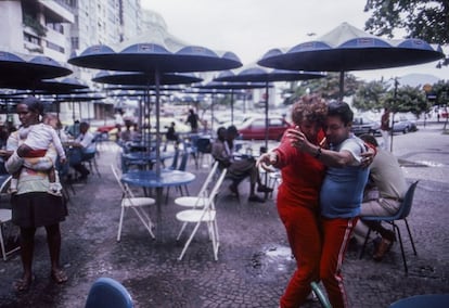 Um casal dança no terraço de um bar.