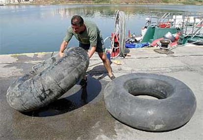 Un agente de la Guardia Civil sujeta uno de los flotadores en los que intentaban llegar a la costa gaditana dos jóvenes magrebíes.