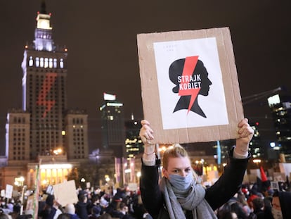 Uma mulher com um cartaz da organização feminista que lidera os protestos contra o Governo da Polônia na sexta-feira em uma enorme manifestação em Varsóvia.