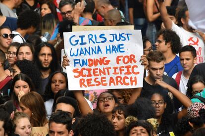 Manifestante exibe cartaz que diz que as meninas querem apenas fundos para pesquisa científica, em São Paulo.