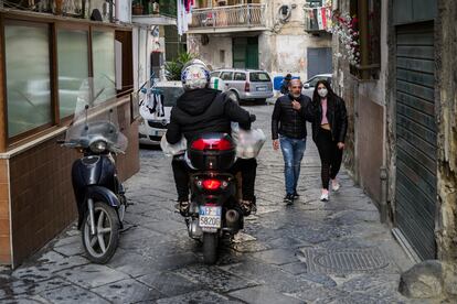 En la moto, Vincenzo y Antonio, voluntarios de la ONG Fondazione San Gennaro, reparten comida a los desfavorecidos, en el barrio Sanità de Nápoles. 