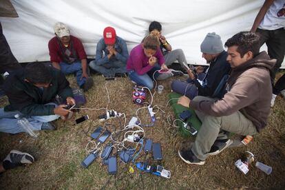 Migrantes aprovechan para cargar sus teléfonos celulares en el albergue, ya que durante el trayecto no tienen la oportunidad de hacerlo con frecuencia. 