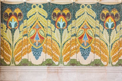 En el salón de actos el telón de fondo de la presidencia simula un cortinaje con pliegues. El dibujo recuerda a las plumas de pavo real.