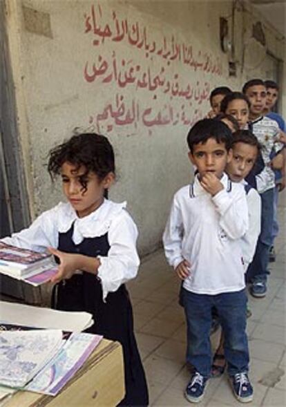 Niños iraquíes hacen cola para recibir el material escolar en Bagdad.