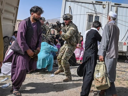 Un soldado estadounidense apunta a un afgano en el aeropuerto de Kabul el 16 de agosto de 2021, en plena salida de las tropas estadounidenses del país asiático.